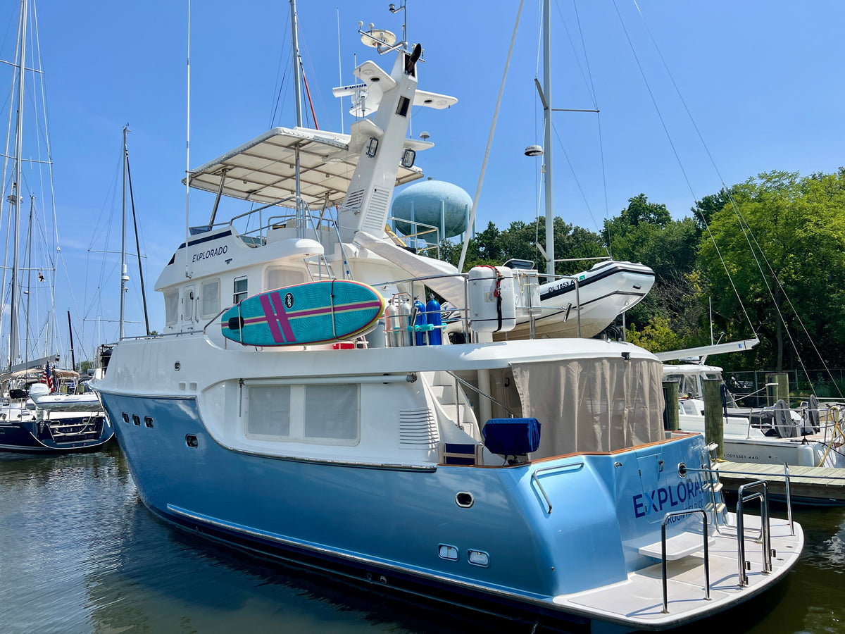 Nordhavn 55 trawler Explorado at the dock, showing the pale blue hull, flybridge hardtop, and exhaust-stack mast after the lithium and electronics refit